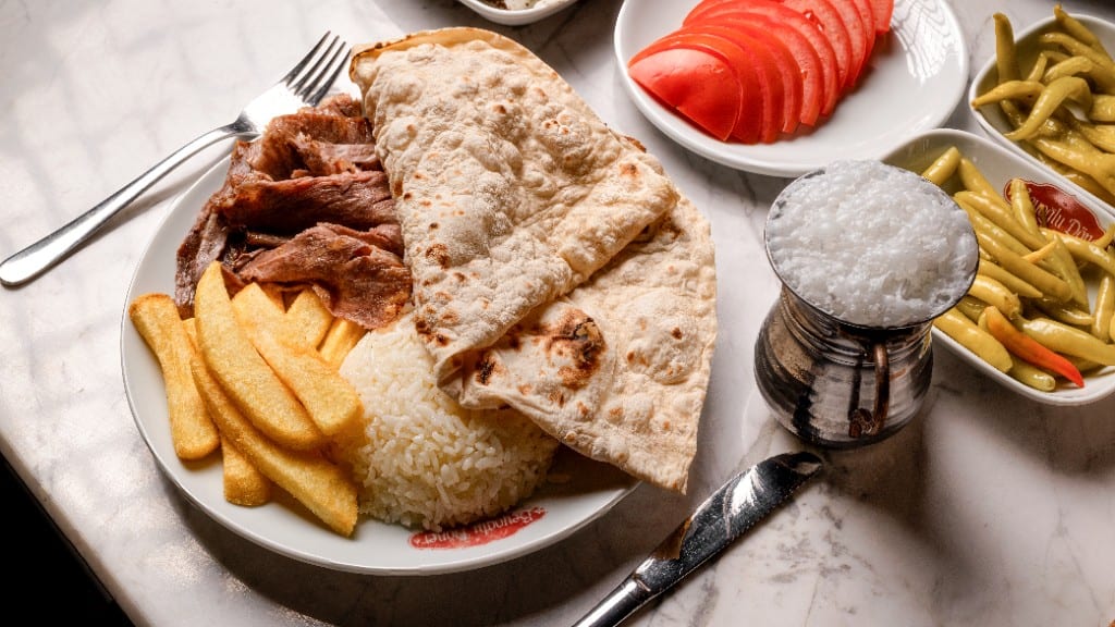 Döner porsiyon, pilav, patates ve bakır maşrapa ayran